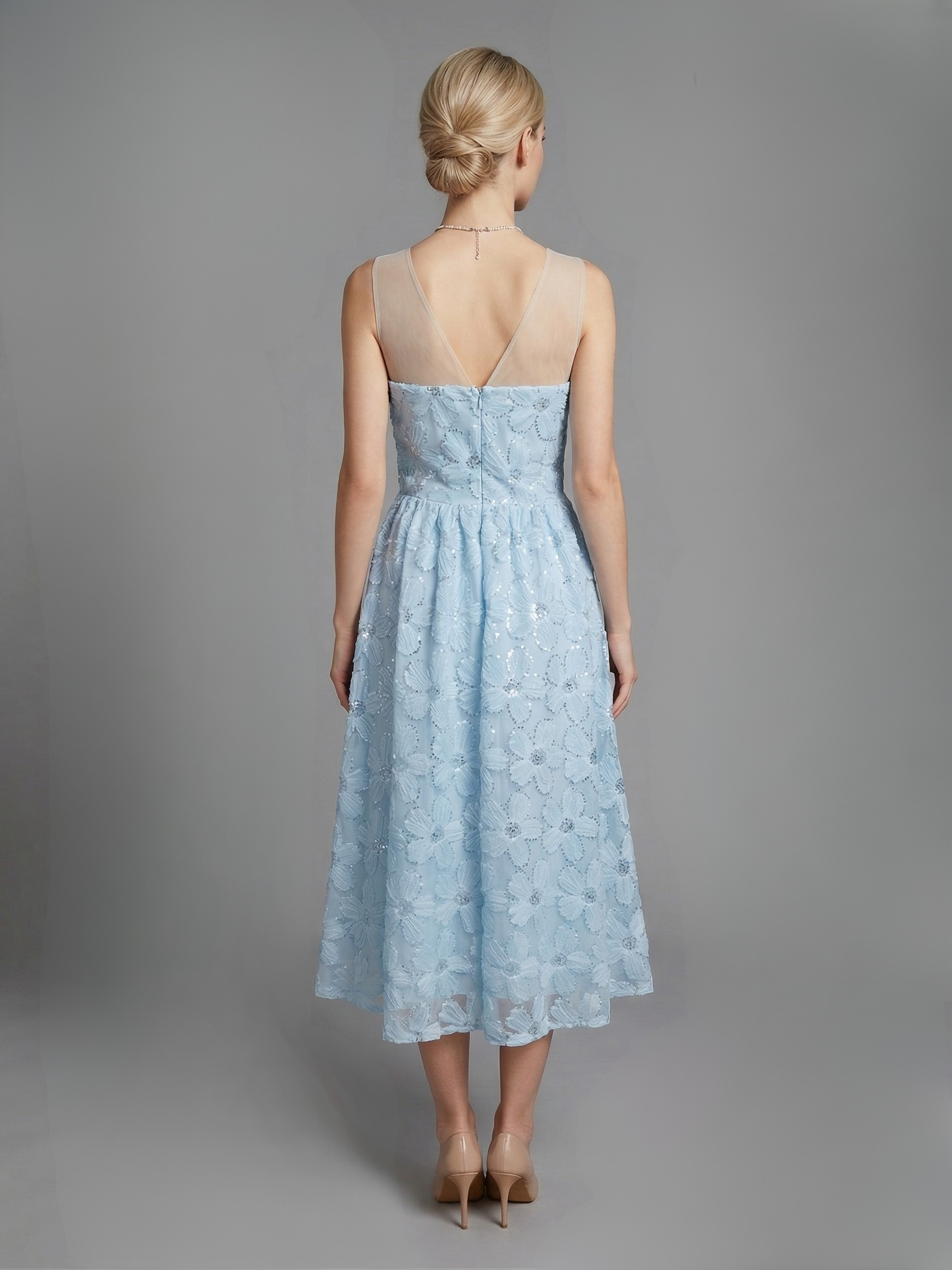 Modelka w Błękitnej sukni z kwiatowej koronki z rozkloszowanym dołem i transparentnym dekoltem widok z tyłu